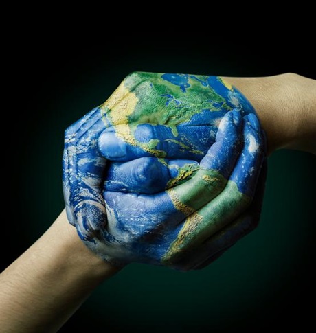 Hands painted into globe and clasping together - Kädet pitävät toisistaan kiinni ja niihin maalattu maapallo.