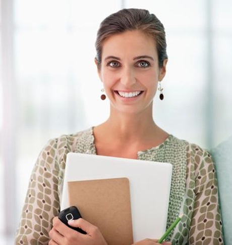 Smiling young woman standing with document - hymyilevä nuori nainen nojaa seinään asiakirjoja kädessään
