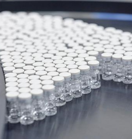 Multiple small vials on production hall table - Iso määrä näytepulloja tuotantohallin pöydällä.